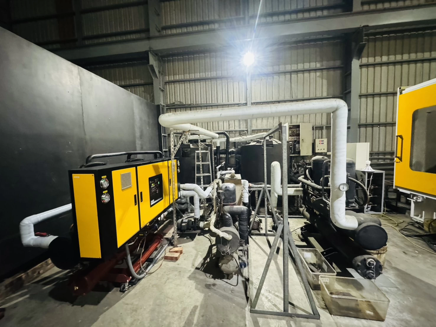 Centralized cooling water system with industrial chillers, pumps, and insulated piping.