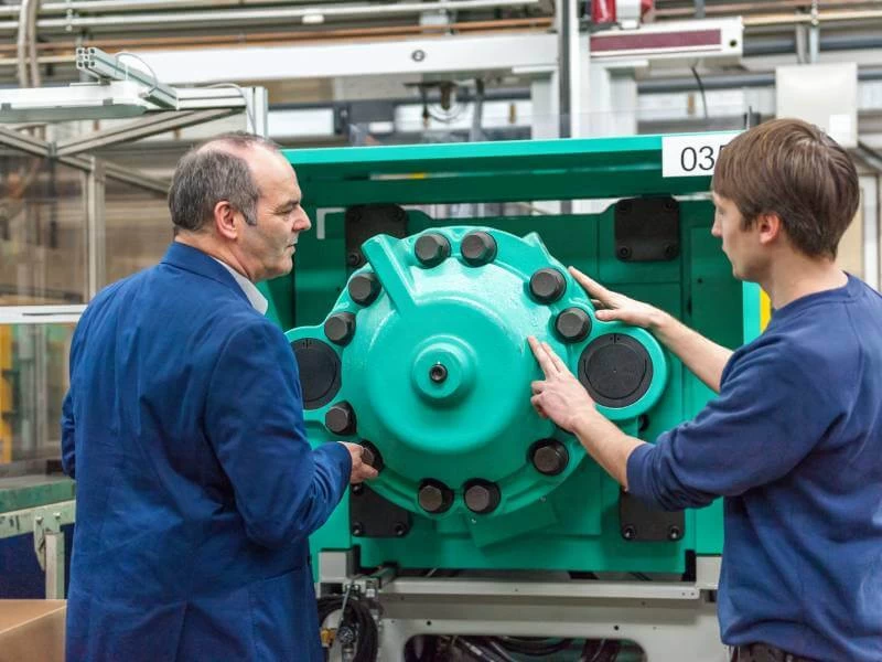 High-tech plastic injection molding machines lined up in a modern factory.