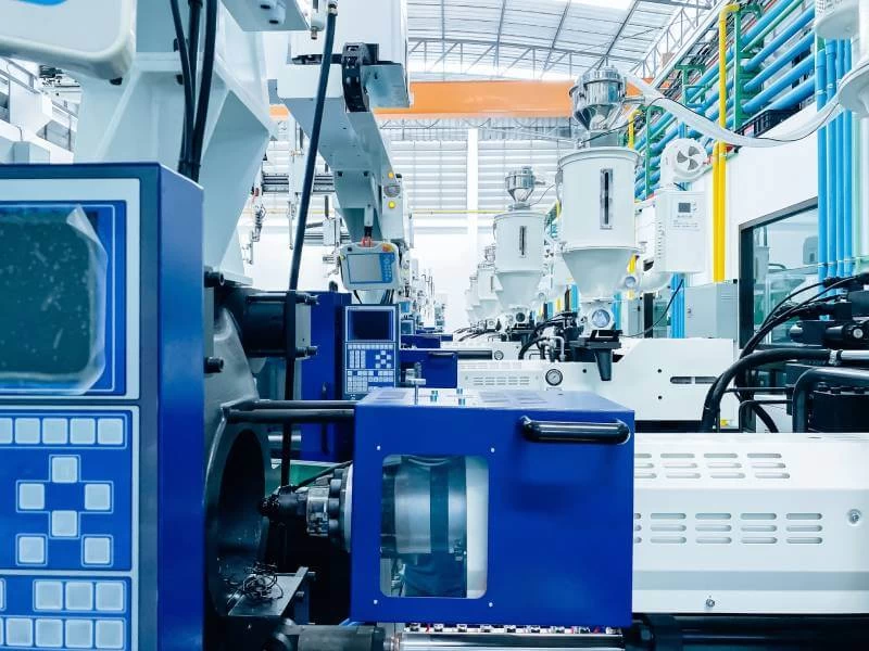High-tech plastic injection molding machines lined up in a modern factory.