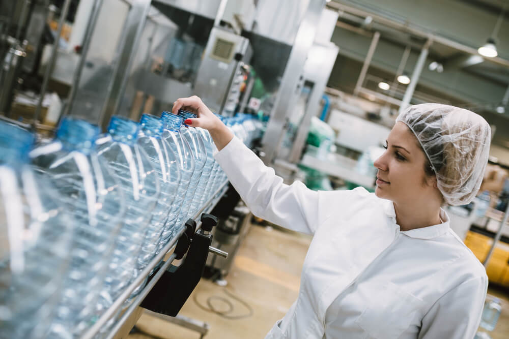 A young female worker checking the plastic-making output.