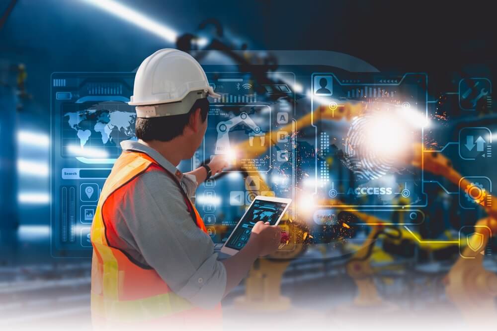 A mechanical engineer using a tablet to control plastics auxiliary equipment.