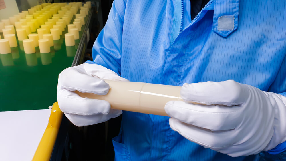 A factory worker checking a plastic part for any weld lines defect.